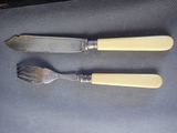 two forks and a knife sitting on a table