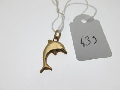 a small gold dolphin necklace with a price tag on it