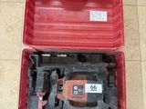 une image représentant une boîte à outils rouge contenant des outils, posée sur un sol carrelé