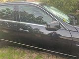 une voiture noire garée sur la pelouse devant une maison