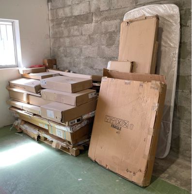 une pile de cartons empilés les uns sur les autres par terre dans une pièce