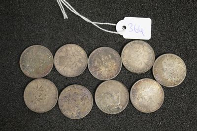 six pièces d'argent sur lesquelles figure un prix, posées sur une surface noire