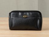 a black leather toilet bag sitting on top of a wooden table