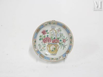 une petite assiette décorée de fleurs, posée sur un fond blanc