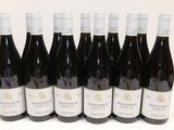 six bouteilles de vin sont alignées sur une table
