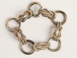 un gros plan d'un bracelet composé d'anneaux métalliques sur un fond blanc