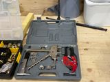 une boîte à outils contenant des outils, posée sur un établi dans un atelier