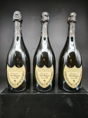 trois bouteilles de champagne posées sur une table noire
