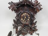 a clock that is hanging on the wall next to a pine cone
