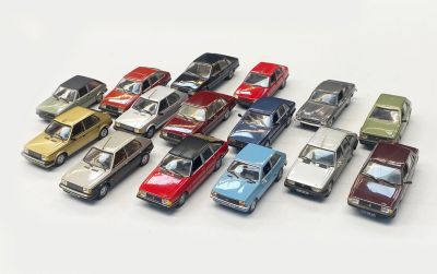a lot of toy cars that are lined up on a table