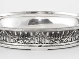 une assiette en argent antique avec un motif décoratif sur le bord