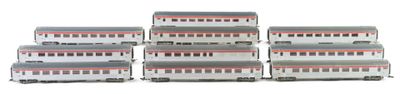 several model trains are lined up in a row on a white surface