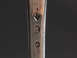 a silver spoon with a silver handle on a black surface