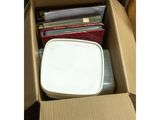une boîte remplie de CD et des CD posés par terre