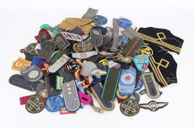 a pile of assorted skateboards and badges on a white surface