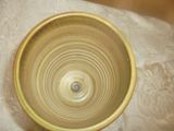 un bol jaune posé sur une nappe blanche