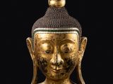 une tête de Bouddha dorée sur fond noir