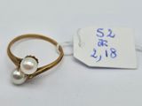 an image of a gold ring with two pearls on it