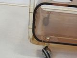 a clear plastic cart with wheels on the floor