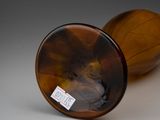 a brown glass vase with a brown lid sitting on a table