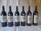 six bottles of wine are lined up in a row on a table