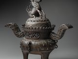 a bronze teapot with a dragon on top of it