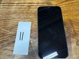 an image of a black cell phone sitting on top of a wooden table