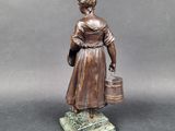 statue of a woman holding a bucket and a bucket of water