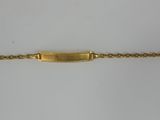 a close up of a gold bracelet on a white surface