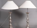 pair of silver metal table lamps with white shades on a grey background