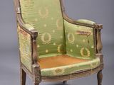 an old chair with a green upholstered seat and a yellow cushion
