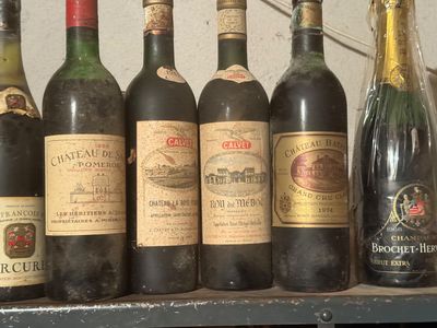 bottles of wine are lined up on a shelf in front of a wall