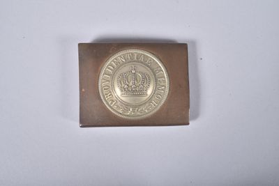 une vieille pièce de monnaie sur laquelle figure une couronne, posée sur une surface blanche
