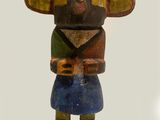 a wooden statue of a woman with a purple feather on her head