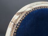 an upholstered chair with a blue velvet upholstered seat