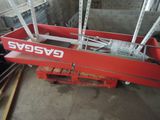 La grande caisse rouge est soulevée par une grue.
