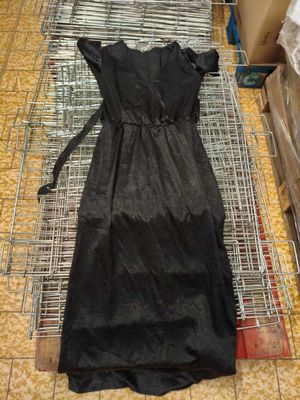 une robe noire posée sur un portant métallique dans un magasin