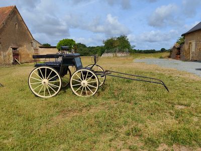 une calèche garée devant une grange