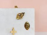 white marble clutch with gold cross, leaf, and leaf broocher