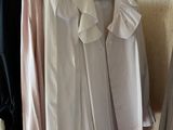 three shirts hanging on a clothes rack in a closet