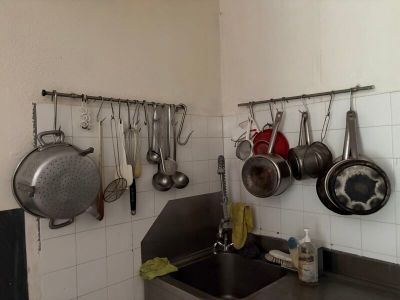 des casseroles et des poêles accrochées au mur d'une cuisine