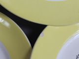 yellow and white plates with black writing on them sitting on a table