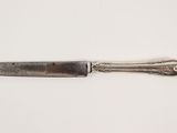 an old silverware knife with a long handle on a white surface