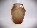 a brown vase with a label on it on a white surface