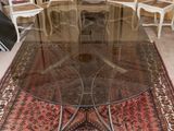 une table avec un plateau en verre et un tapis posé au sol
