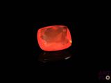 a close up of a glowing red diamond on a black surface