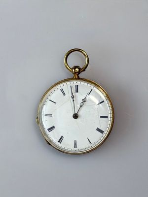 a gold pocket watch with roman numerals on the face