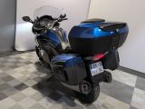 a blue motorcycle parked in a room with a checkered floor