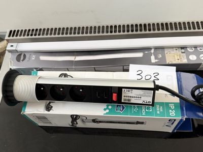 une multiprise posée sur une boîte, à côté d'un ordinateur portable