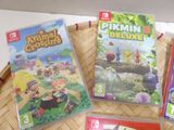three nintendo wii games sitting on top of a wooden tray
